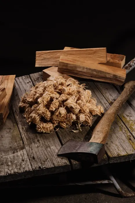 Holzwolle, Anzündholz und Axt auf der Werkbank