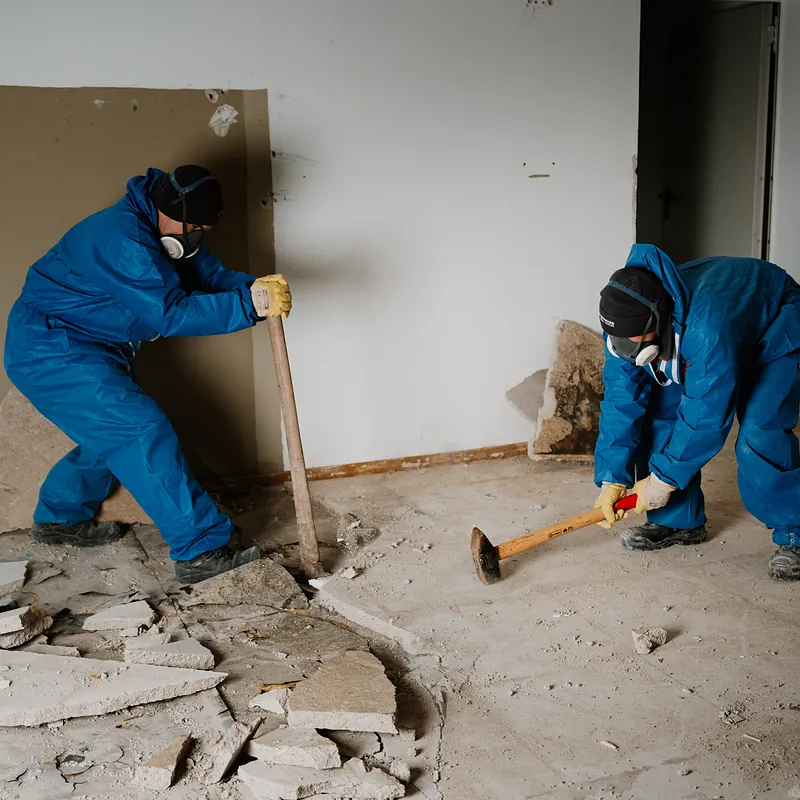 Zwei Mitarbeiter beim Rückbau eines Bodens im Innenbereich
