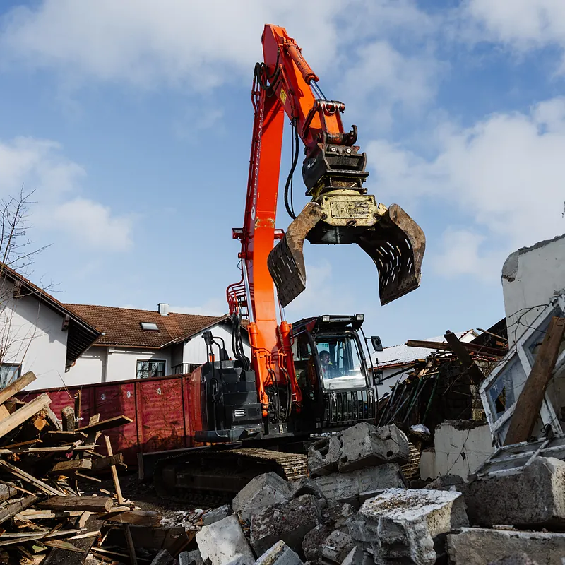 Bagger mit Abbruchzange über Bauschutt