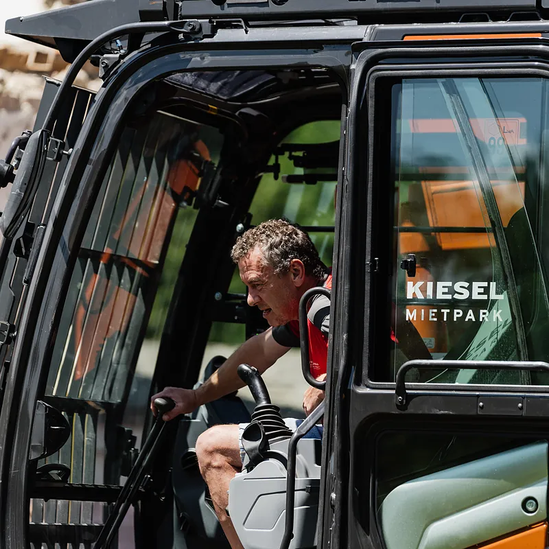 Maschinenführer in der Kabine eines Abbruchbaggers