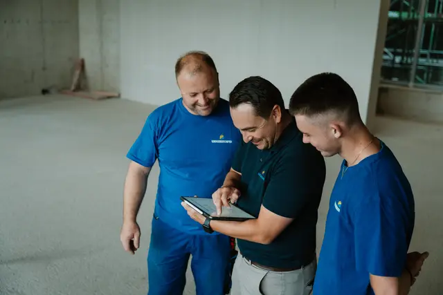 Team schaut gemeinsam aufs Tablet